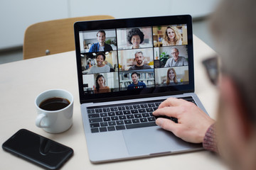 Person Using Video Conferencing technology in kitchen for video call with colleagues at home and in offices