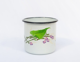 Vintage enameled mug with bamboo and violet flower - isolated on white background