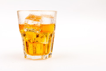 Glass of scotch whiskey and ice over white background.