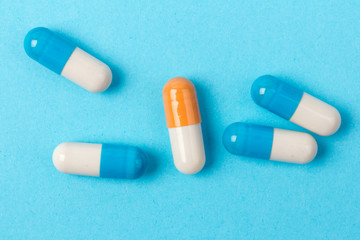 Pills isolated on blue background.Colorful medical drug capsule.