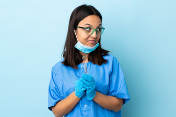 Young brunette mixed race dentist woman holding tools over isolated background scheming something