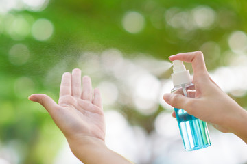 Close up hand with alcohol sanitizer spray outdoor