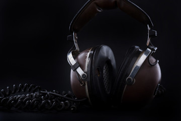 Fototapeta na wymiar Old headphones on black background
