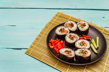 Korean roll Gimbap(kimbob). Steamed white rice (bap) and various other ingredients. Trendy turquoise background