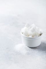 Sugar cubes and grain of sugar