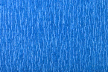 Background of blue pressed corrugated paper with vertical texture taken close up