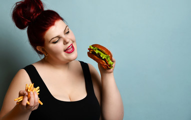 Happy overweight fat woman happy hold burger cheeseburger sandwich with beef and french fries in hand