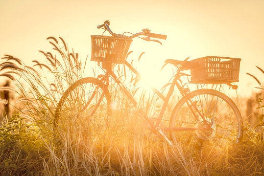 beautiful landscape image with bicycle at sunset ; vintage filter style