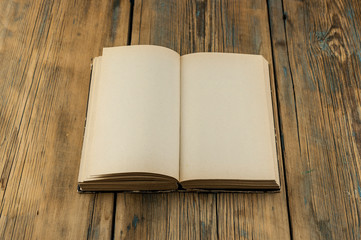 Fototapeta premium Vintage book, open, on old wooden table.