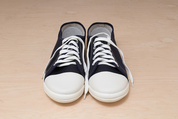 New clean unworn sneakers over light wooden background