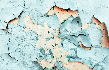 Texture of old blue and orange cracked paint at wall surface. close-up