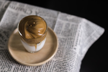 Iced Dalgona Coffee, a trendy korean style  cremy whipped coffee on fresh milk, on wooden tray on the table