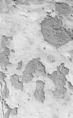 Close-up of a weathered and old concrete wall, white paint is peeling off. High resolution abstract full frame textured background in black and white.
