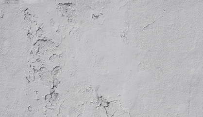 Close-up of a weathered and old concrete wall, paint is peeling off. High resolution abstract full frame textured background in black and white.