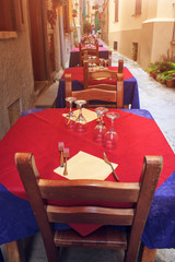 Southern Italy street terrace of restaurant. Served tables of restaurant on old town street in morning.