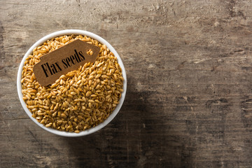 Golden flax seeds on wooden table top view. Copy space	