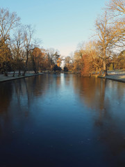 slightly frozen pond in a park