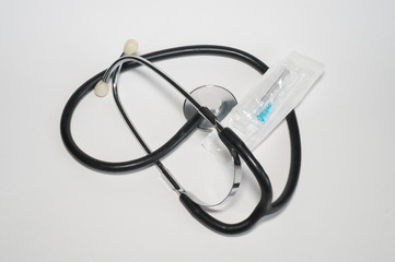 Stethoscope, disposable plastic syringe in cover
