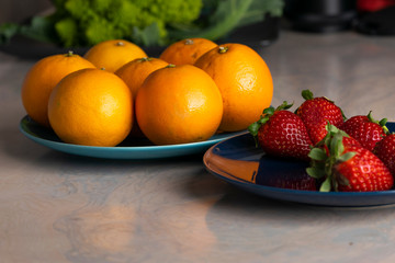 Fruits plates with oranges and strawberries on a dining table for healthy dish