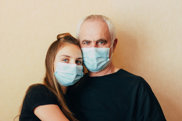 teenage girl help grandfather and support during pandemic, looks at camera leaning on his shoulder.  .granddaughter worry about senior man on world pandemic of coronavirus epidemic. Elderly risk zone
