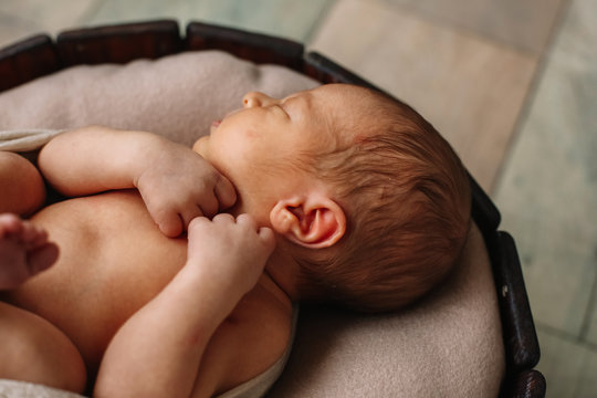 
Newborn baby boy, in the photo the baby is 7 days old from birth, wrapped in a wrapping, sleeps sweetly in a basket