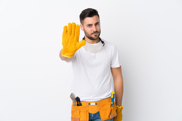 Craftsmen or electrician man over isolated white background making stop gesture with her hand