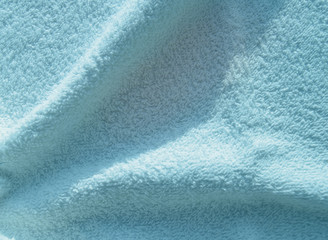 Blue fluffy Terry towel, a simple example of the texture of a soft, fleecy fabric, a background of...