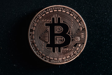 Bitcoin on black background. Photo in the dark key