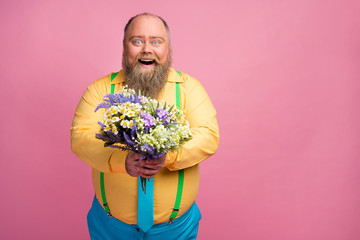 Portrait of his he nice affectionate careful funky glad positive bearded guy giving you fresh flowers congratulating isolated over pink pastel color background