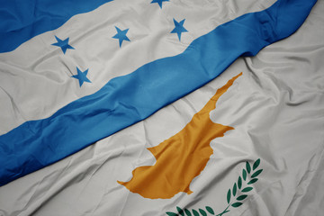 waving colorful flag of cyprus and national flag of honduras.