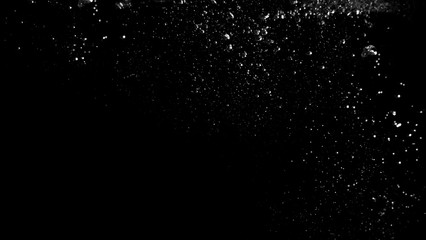 Blurry images of real soda bubbles floating and splashing up in black background which represent...