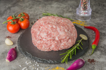 Pork mincemeat black slate with spices. Red meat texture with white fat texture, close-up