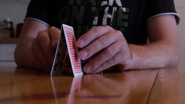 young man is failing at building a house of cards