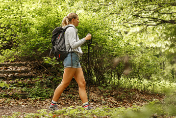 Young blond hair woman hiking in nature.	
