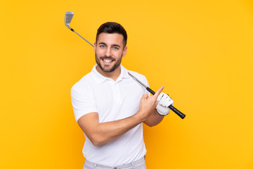 Golfer player man over isolated yellow background pointing to the side to present a product