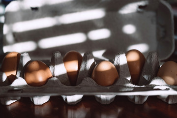 Raw brown eggs in tray alternating with empty spaces. Concept of Easter with social distancing in...