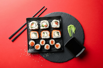 Delicious sushi rolls on red background. Japanese food © Atlas