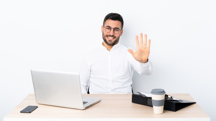 Young businessman in a workplace counting five with fingers