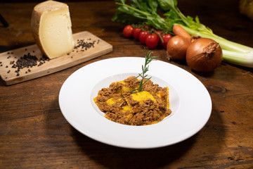 Mugellani potato tortelli with Bolognese sauce with rosemary from the table of an old tavern