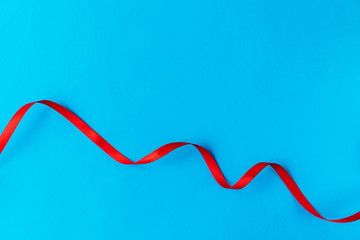 Wavy red ribbon on a blue background. A good idea for a holiday card or background for text, like a computer wallpaper or a screensaver on your phone