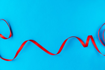 Wavy red ribbon on a blue background. A good idea for a holiday card or background for text, like a computer wallpaper or a screensaver on your phone