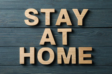 Stay at home made of wooden letters on wood background. Quarantine