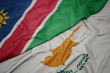 waving colorful flag of cyprus and national flag of namibia.
