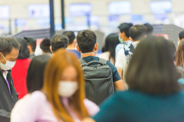 Crowd of people in masks waiting in airport during coronavirus quarantine