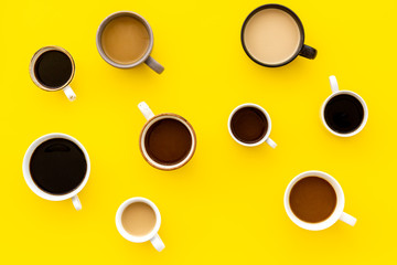 Many cups of coffee on yellow background top view pattern