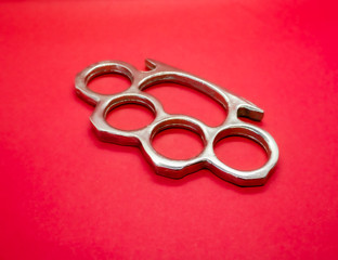 silver knuckle duster on red background 