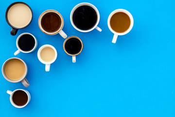 Many cups of coffee on blue background top view copy space