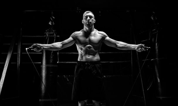 The athlete jumps on a skipping rope in the gym opposite the boxing ring. The concept of sport, bodybuilding, fitness, healthy lifestyle.