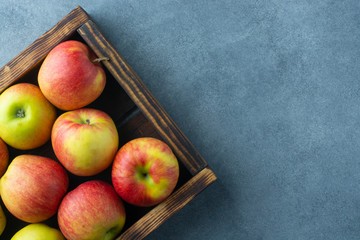 Fresh apples in a wooden crate. View from above. Free space for an inscription.