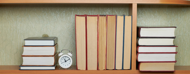 Education learning concept with opening book or textbook in old library, stack piles of literature text academic archive on reading desk and aisle of bookshelves in school study class room background © Mikhail